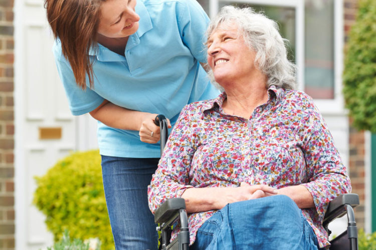 home-care-worker-talks-to-an-elderly-lady-in-a-garden